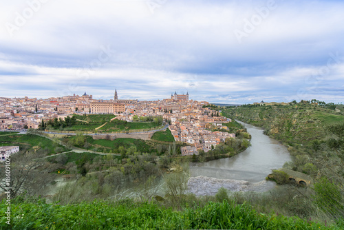 Panoramic view of Toledo, Spain during spring twilight. The ancient city sits on a hill surrounded by the Tagus River, creating a natural moat.