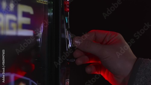 Inserting coins into a slot machine for gambling. Feeding two Euro coins into the game machine in a casino. Close-up of the hand with the cash money.