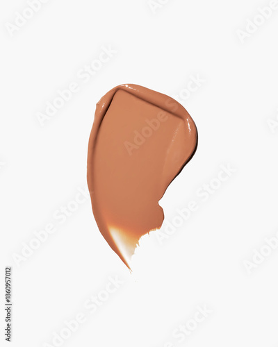 Smooth caramel colored foundation smear on white background