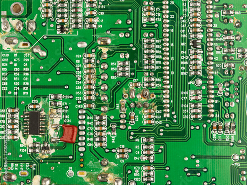 A close-up of a green printed circuit board from an electrical appliance or computer. Concept of electronics and microprocessor technology