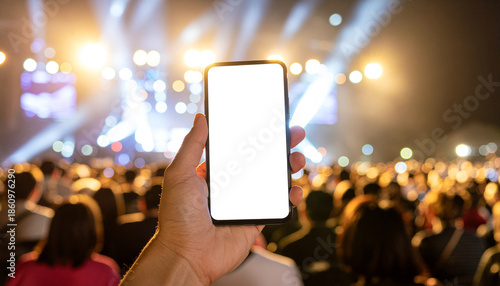 A hand holds a blank phone at a live concert with stage lights. Ideal for music apps, event tickets, or social media content.