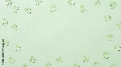 Soft pale green background with scattered small light green four leaf clovers, minimalistic st patricks day themed flat lay with copyspace