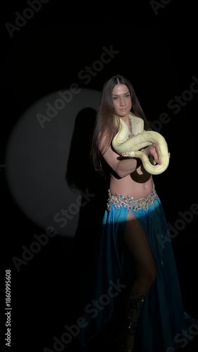 Exotic Dancer Posing with Albino Python in Spotlight