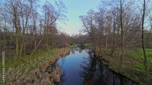 A low and fast drone flight over a river and meadow.