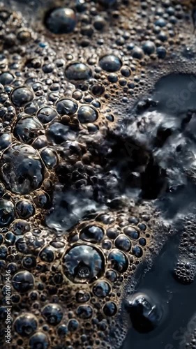 Close-up of dark oily bubbles floating on water surface. Toxic crude oil spill pollution texture. Environmental disaster and industrial waste concept