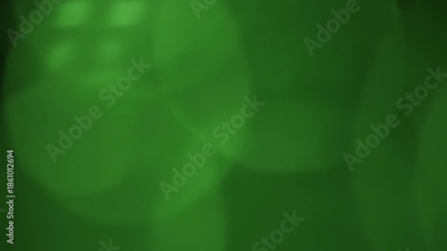 Abstract image of soft green and white light patterns. The image appears to be out of focus. It is filled with circular shapes that are blurred. The colors create a visual effect