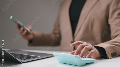 Business Person Calculating Finance with Digital Device, Laptop, and Calculator