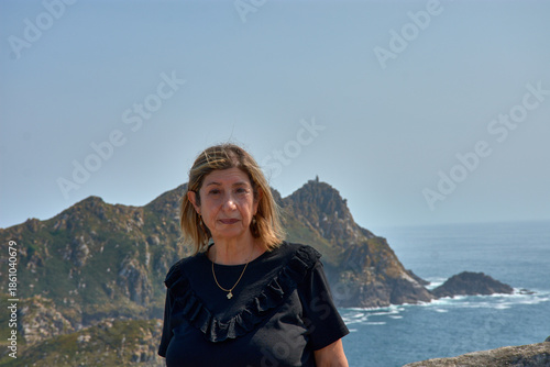 Senior woman enjoying the breathtaking views of the Cies Islands landscape.