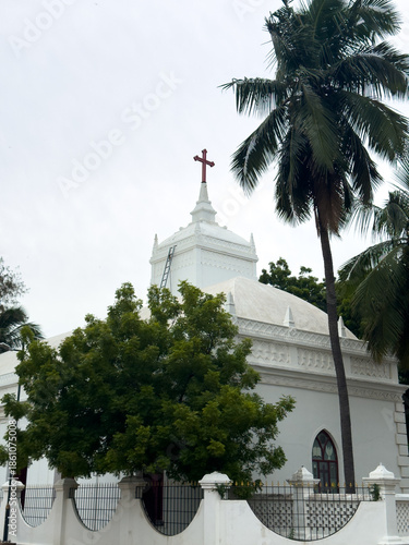 White facade of Zion Church with a cross atop and palm trees in Tharangambadi, Tamil Nadu, a historic Danish colonial-era Protestant church.
