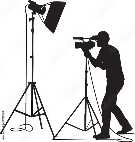 Cameraman operating video camera with studio light setup silhouette