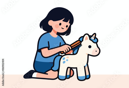 Cheerful child brushes a toy unicorn