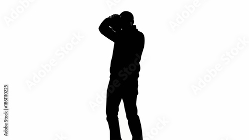 Silhouette of a person holding a camera and taking a photo.