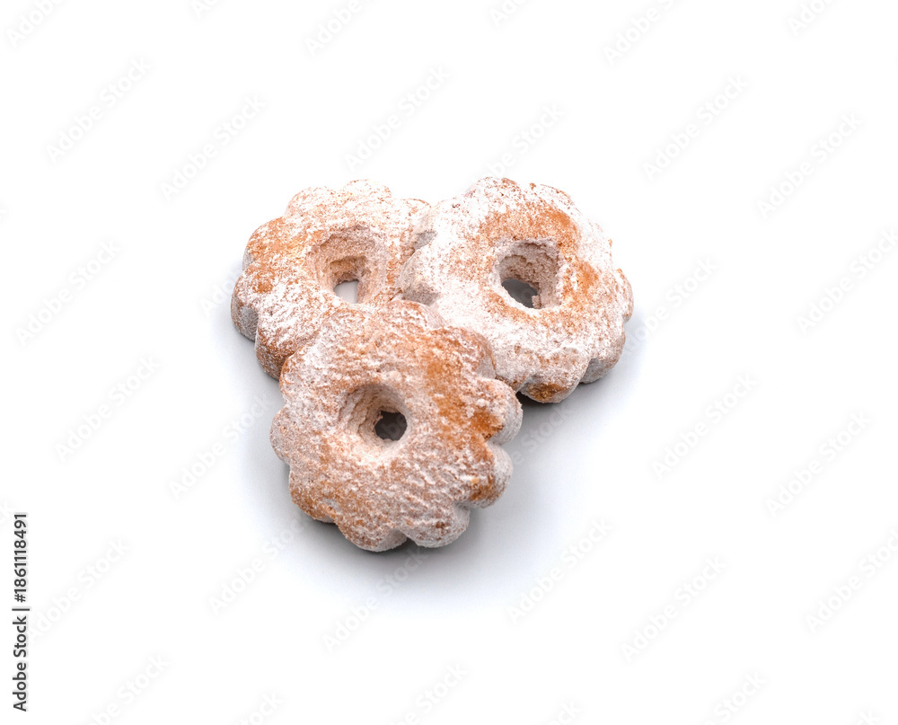 Fototapeta premium Flower-shaped cookies dusted with powdered sugar on white background.