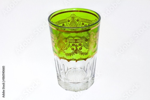 Wallpaper Mural Top view of a traditional Moroccan tea glass with vibrant green tint and golden decorative patterns Torontodigital.ca