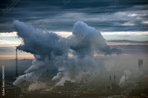 Industrial landscape with heavy smoke from power plant chimneys.