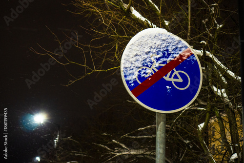 Canvastavla Close up of an end of bicycle lane road sign covered with fresh snow at night