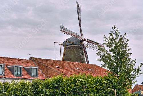 Windmill De Graanhalm Stalk of Grain in Gapinge Zeeland Netherlands With Red Tile Roofs And Greenery Under A Cloudy Sky European