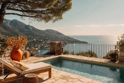 Sunny pool overlooks a serene coastline with a distant town and towering mountains