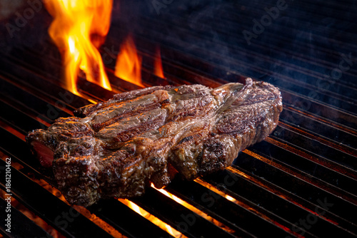 Carne sobre la parrilla con fuego y carbón.