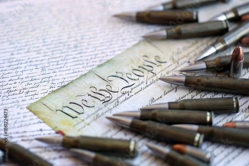 The second amendment and gun control in america concept. Bullets on american constitution with close up on We The People part of the United States constitution