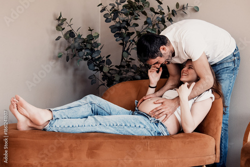 Married couple man and pregnant woman belly pose photo shoot expectant parents