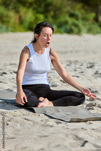 Adult woman practicing pranayama breathing exercise on Sandy Beach near Baltic Sea
