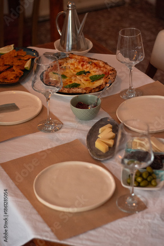 Restaurant table set with glasses and neapolitan pizza