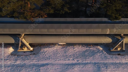 Wallpaper Mural Vivid scene displaying pipeline infrastructure illuminated by sunset amidst snowy urban rooftops vividly Torontodigital.ca