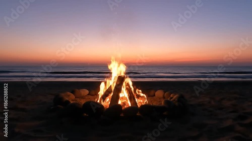 Campfire on beach at sunset with ocean horizon