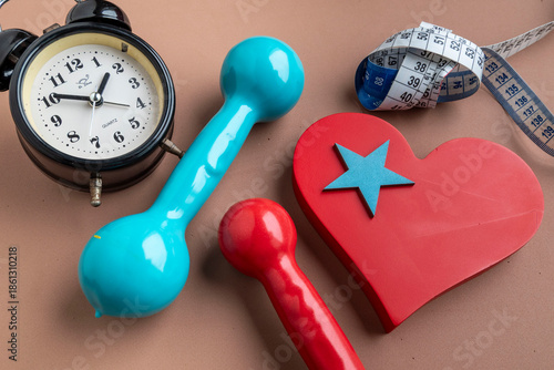 Heart-shaped, with weights for exercise and a measuring tape. Time to start gym