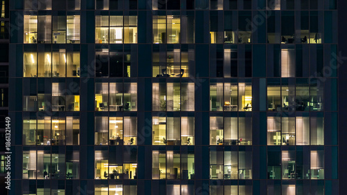 window of the multi-storey building of glass and steel lighting and people within timelapse