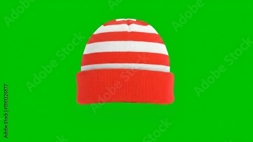 Red and white striped winter hat isolated on green screen
