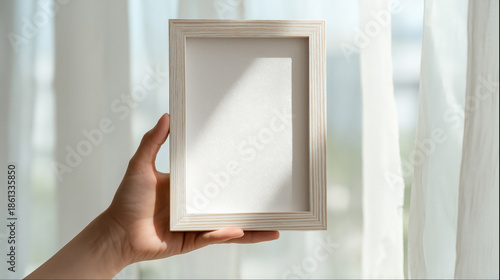 hand holding blank white frame