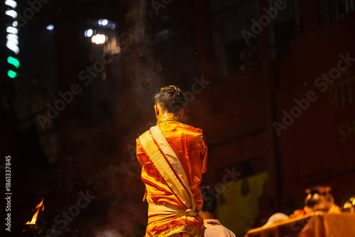 Ganga aarti, Portrait of an young unidentified male priest performing holy river ganga evening aarti at dashashwamedh ghat in traditional dress with hindu rituals.