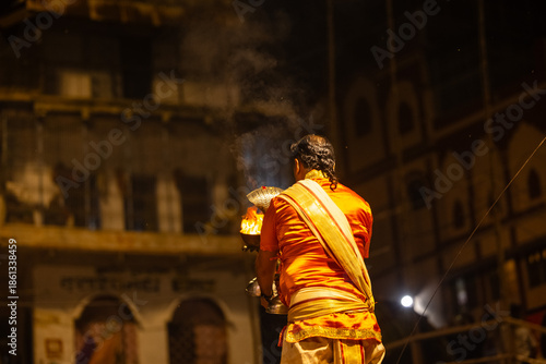 Ganga aarti, Portrait of an young unidentified male priest performing holy river ganga evening aarti at dashashwamedh ghat in traditional dress with hindu rituals.