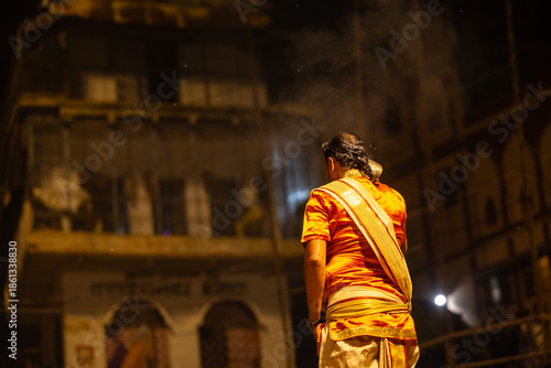 Ganga aarti, Portrait of an young unidentified male priest performing holy river ganga evening aarti at dashashwamedh ghat in traditional dress with hindu rituals.