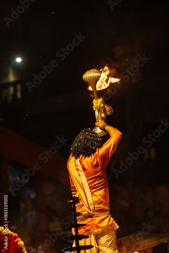 Ganga aarti, Portrait of an young unidentified male priest performing holy river ganga evening aarti at dashashwamedh ghat in traditional dress with hindu rituals.