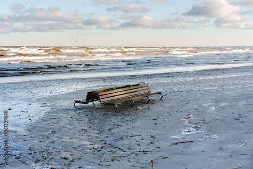 Lonely Wooden Bench on a Sandy Beach with Sea Waves and Clouds, Latvia, Jurmala