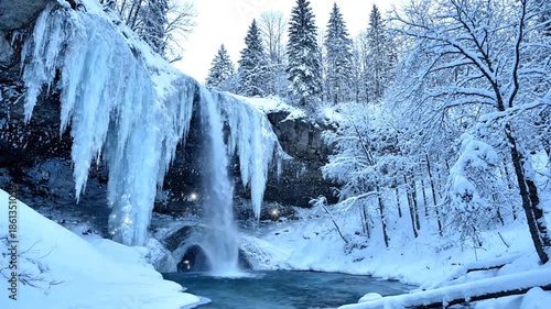 Frozen waterfall cascading through snowy winter landscape