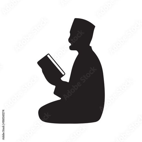 a silhouette of a man kneeling and reading from a book possibly religious text in black and white
