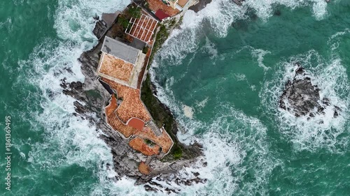 Aerial view of the vibrant Erchie beach with its historic coastal tower, set against the turquoise sea and rocky cliffs, Erchie, Amalfi Coast, Italy.