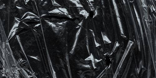 Wrinkled plastic wrap texture on a black background. Cellophane package wallpaper