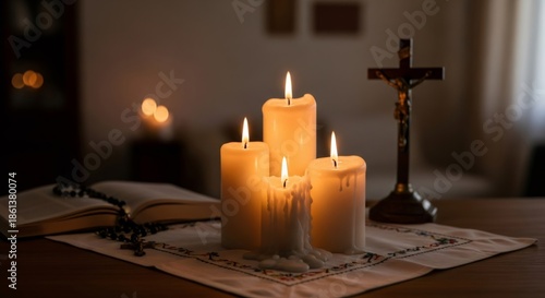 Four lit candles on a table with a crucifix, an open book, and rosary beads. Religious prayer and meditation concept for Palm Sunday.
