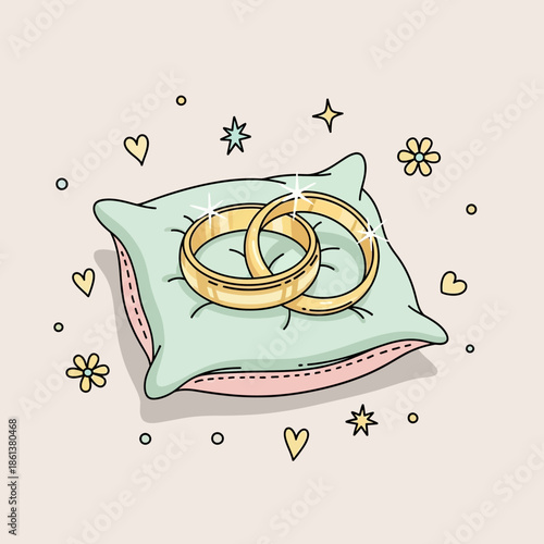 Two golden wedding rings resting on a decorative pillow.