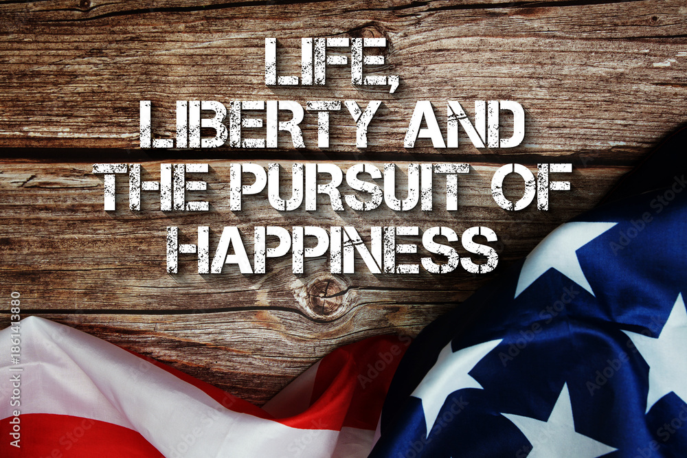 Fototapeta premium Life, Liberty And The Pursuit Of Happiness text message with USA flag on wooden background