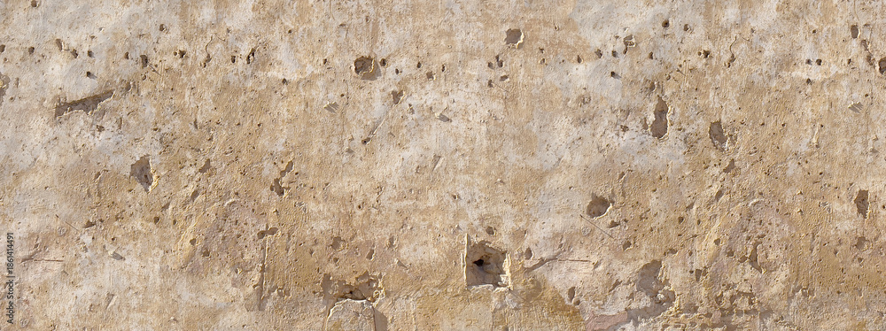 Obraz premium Distressed stucco wall surface showing bullet holes damage