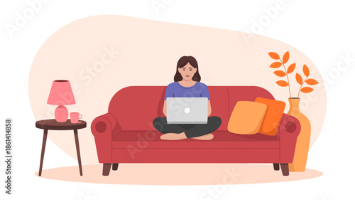 Young woman comfortably working from home on a red sofa, focused on her laptop in a cozy setting