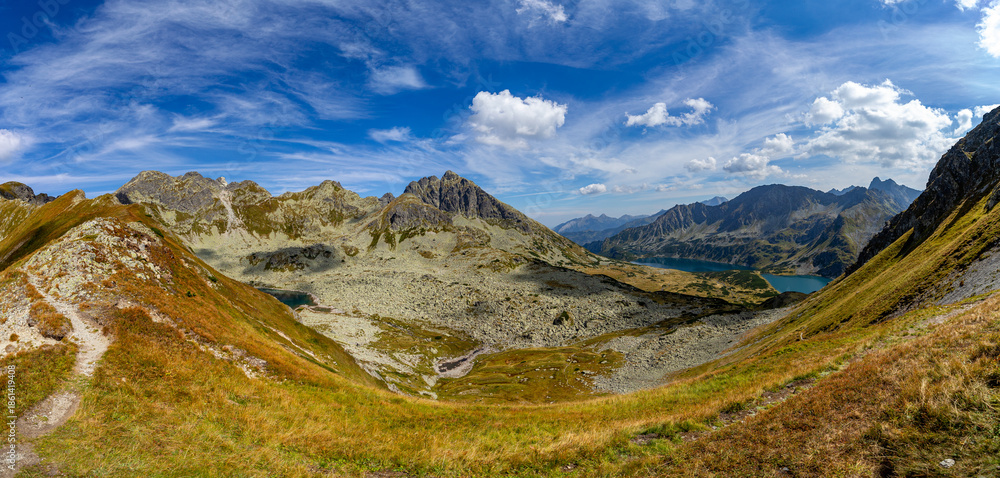 Fototapeta premium A spectacular panoramic view from Hladke sedlo overlooking turquoise mountain lakes and jagged peaks. This scenic landscape in the High Tatras shows the majestic beauty of the border between Slovakia 
