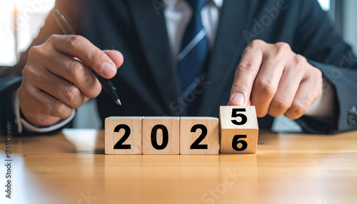 Wallpaper Mural Businessman flipping wooden blocks to change year from 2025 to 2026, business planning and goals for new year, vision, strategy and preparation concept. Torontodigital.ca
