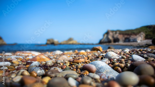 Close-up of Colorful Beach Pebbles by the Sea. Blurred background.